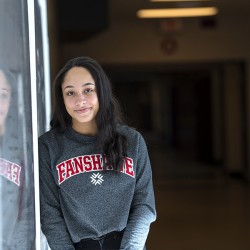 A student looks at the camera while leaning in the hallway at Fanshawe College
