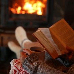 Reading a book near a fireplace