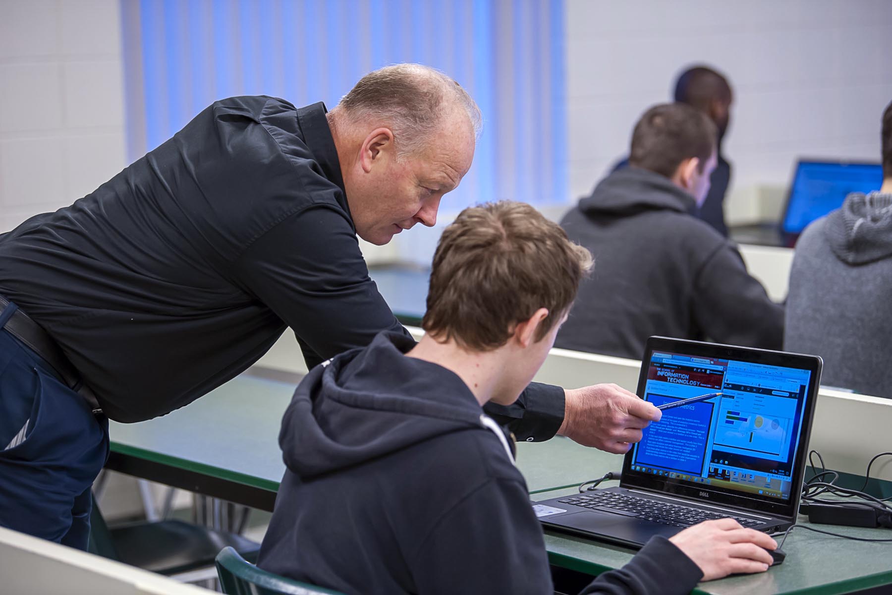 Computer systems instructor helping a student