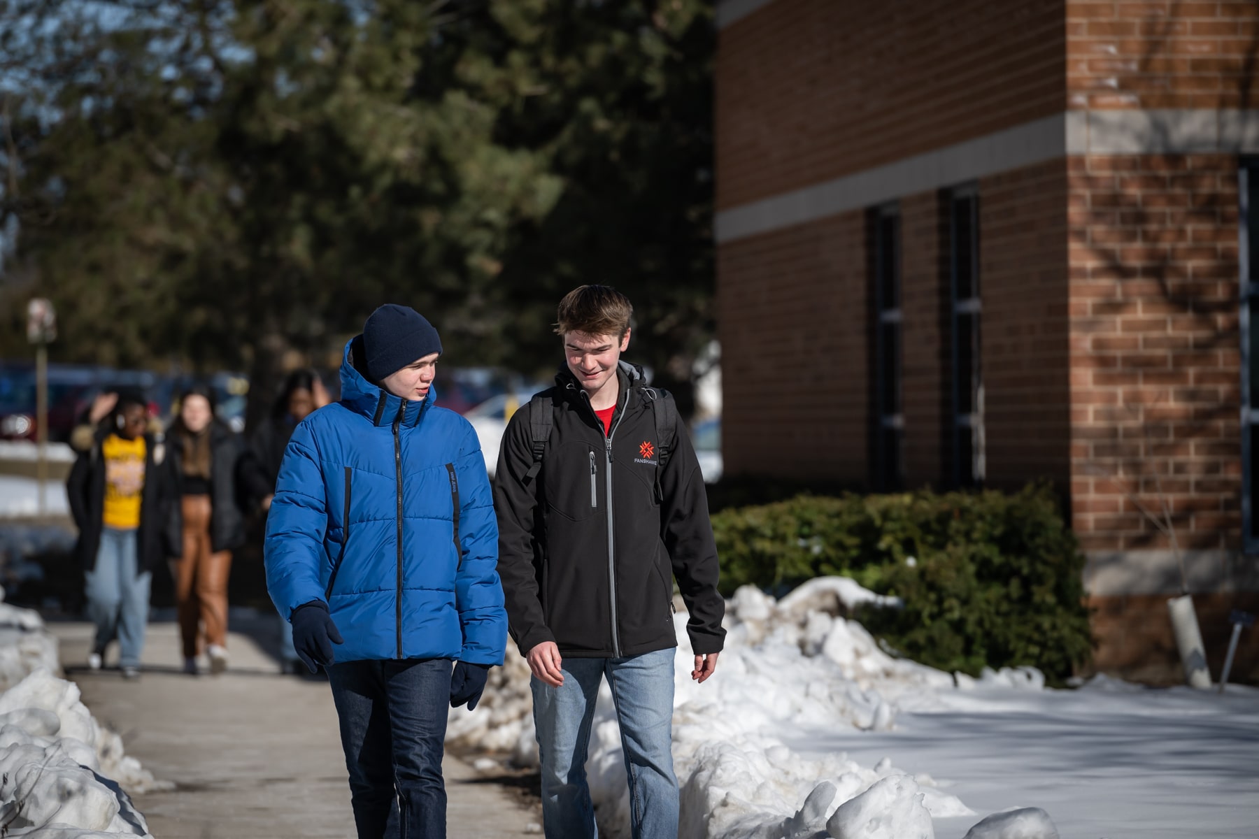 two students walking together in winter
