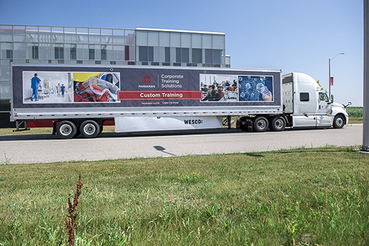 Fanshawe's CTS Transport Truck with trailer in front of building