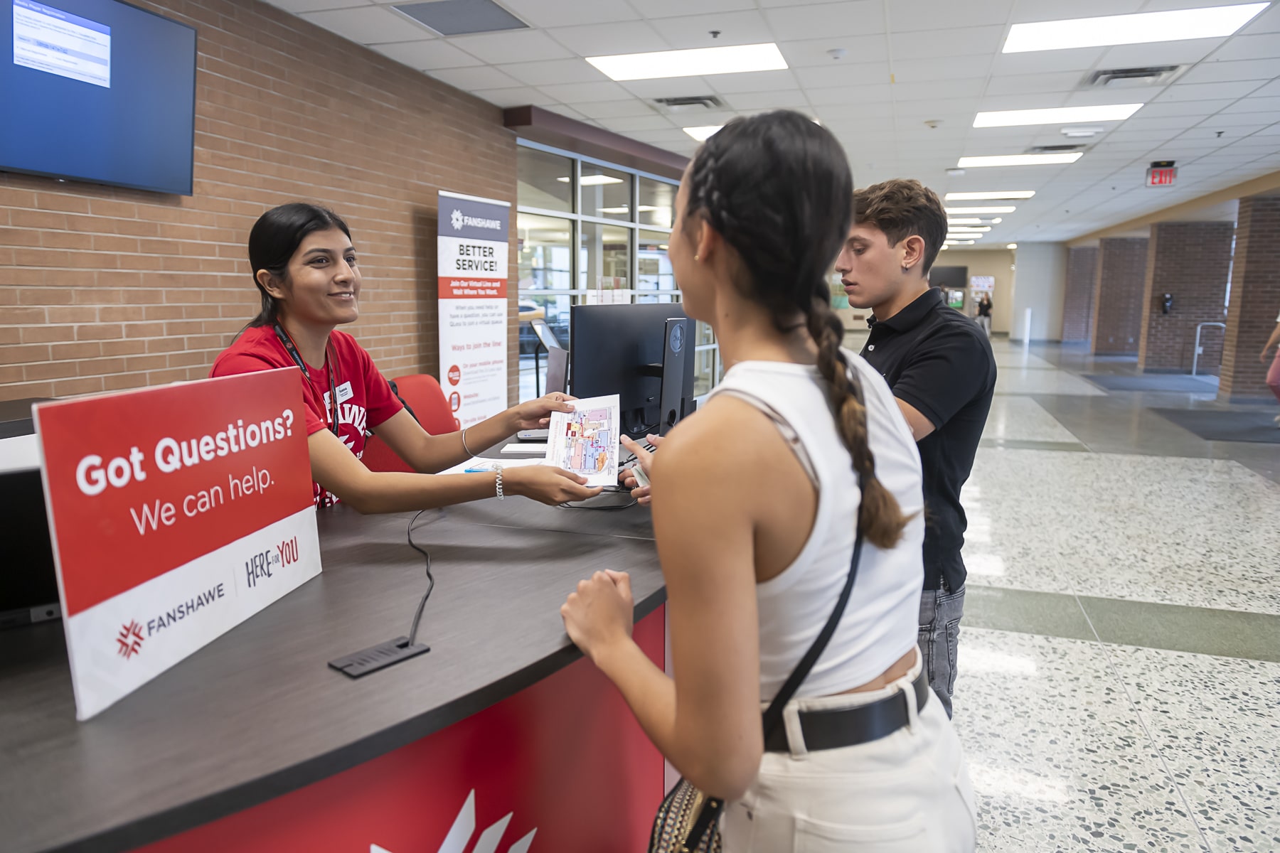 Fanshawe employee hands students a map at orientation