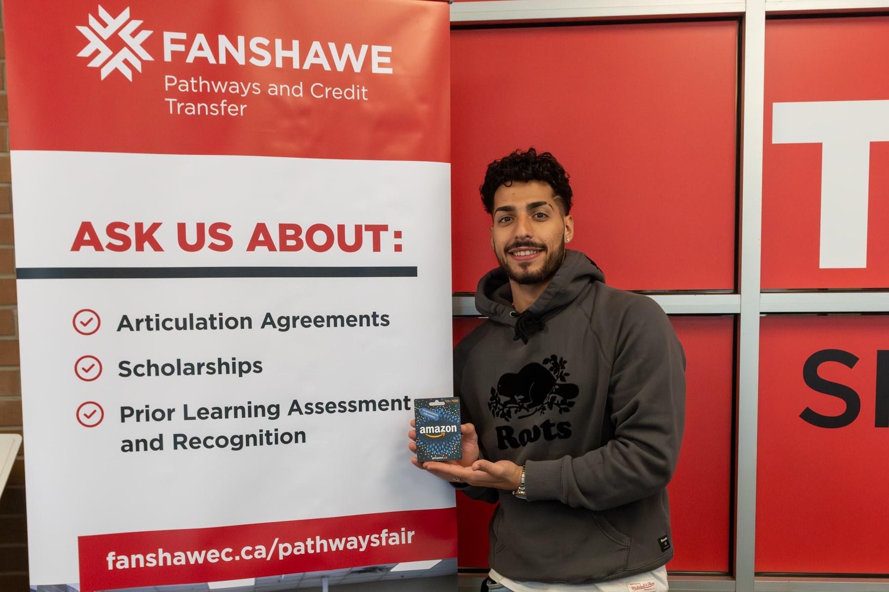 winning student holds up gift card at Fanshawe's Pathways Fair