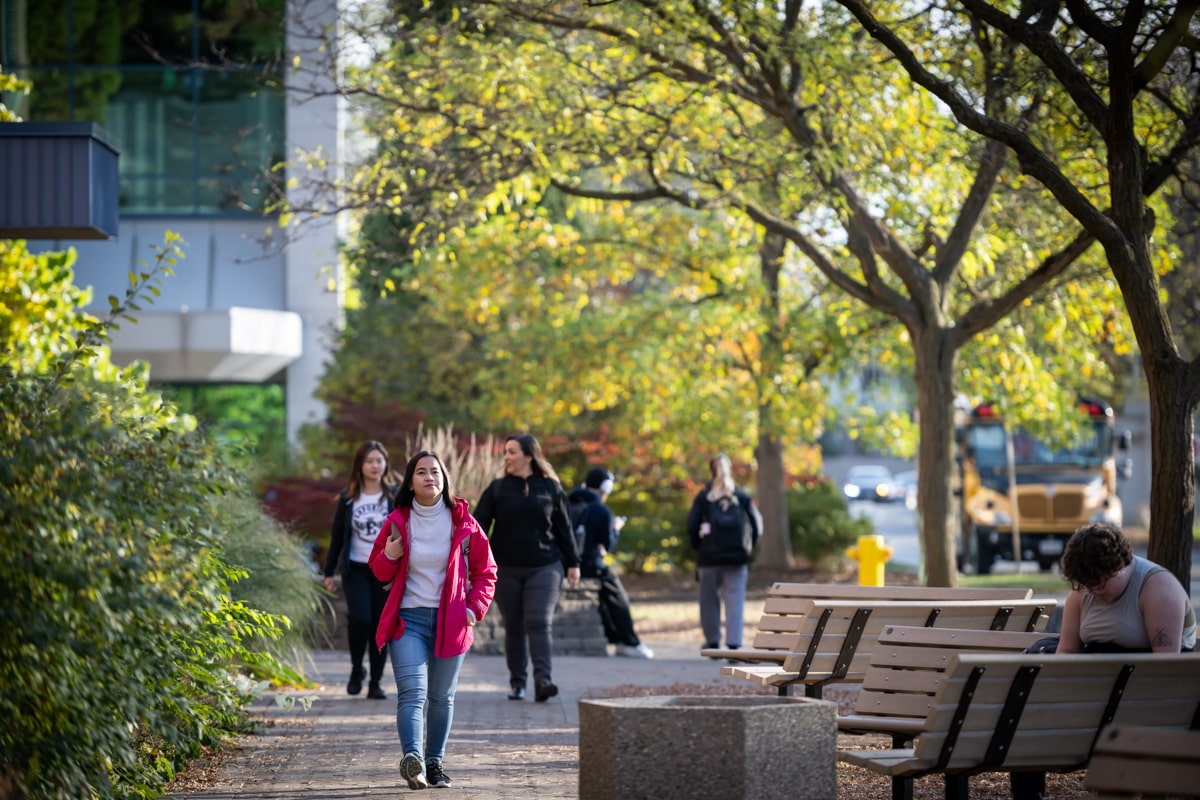 students walk outdoors on Fanshawe campus paths