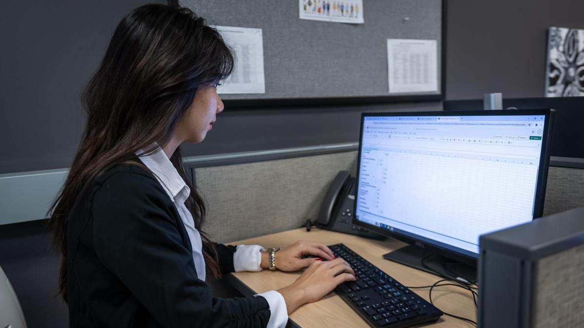 administrative student sits at computer, typing