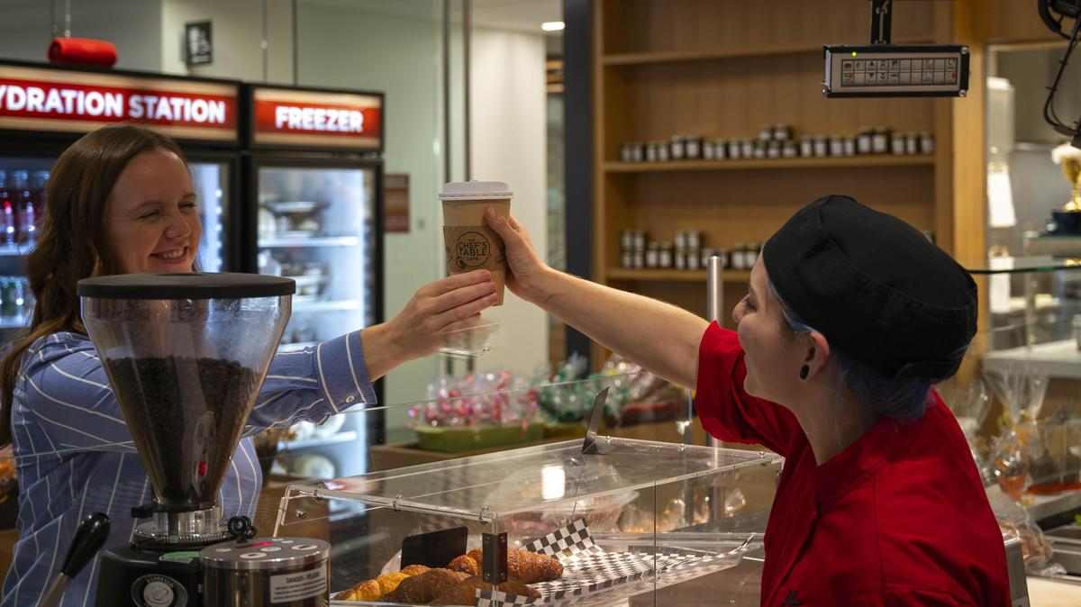 food worker hands customer a coffee