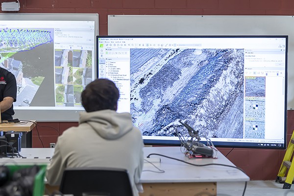 students sit in classroom reviewing drone images