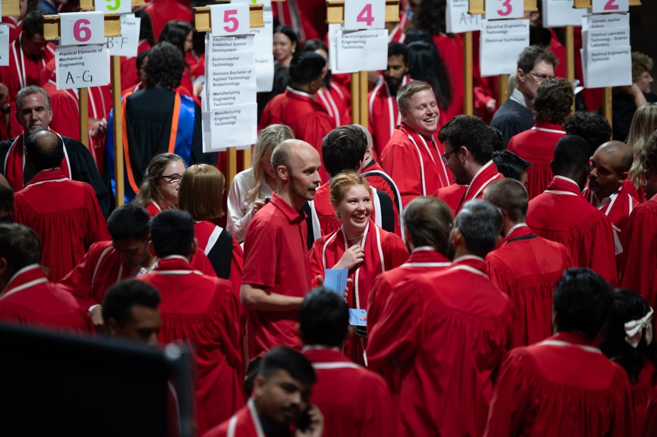 Graduates organize themselves by signage at convocation