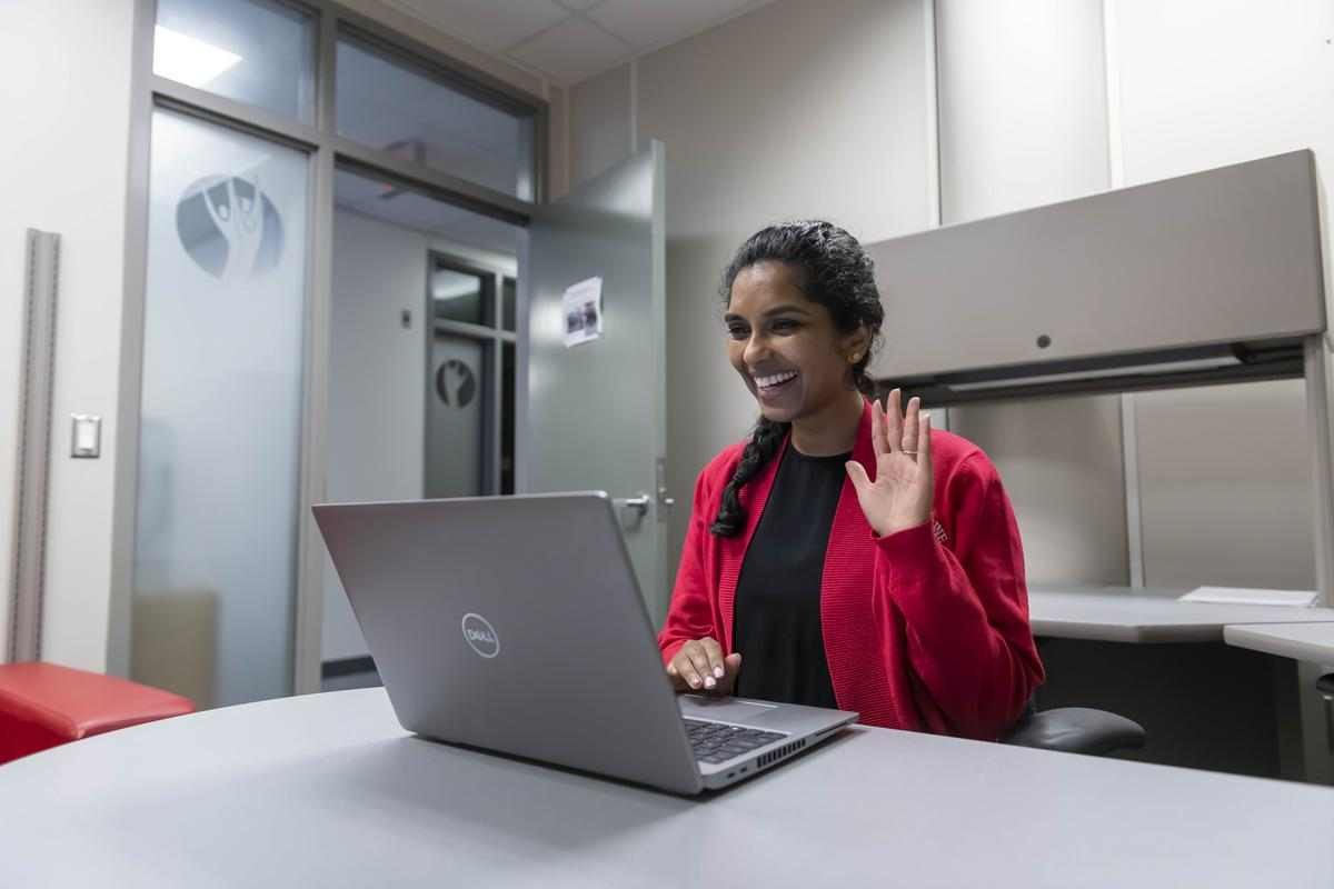 counsellor waves at camera during online appointment